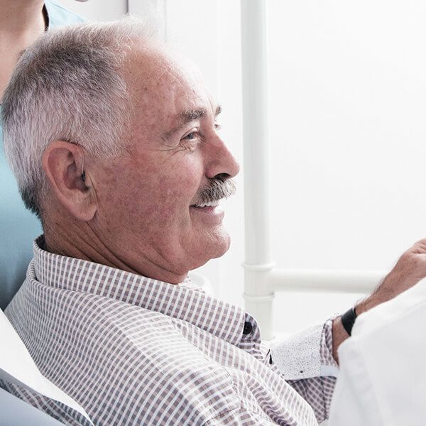 An older gentleman in a dental chair ready for periodontal treatment
